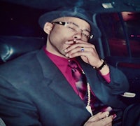 a man in a suit smoking a cigarette